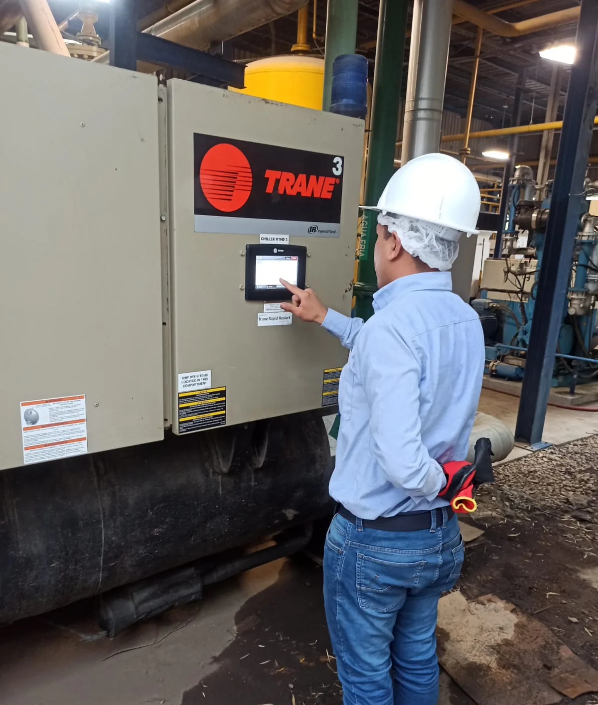 Técnico revisando el panel de control de un chiller Trane