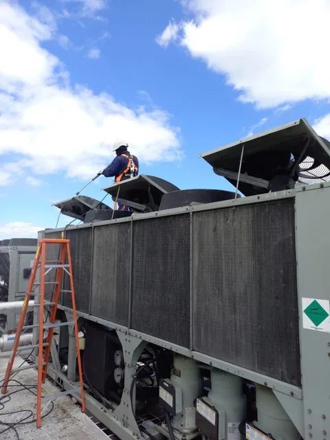 Técnico lavando los serpentines de un chiller en cubierta